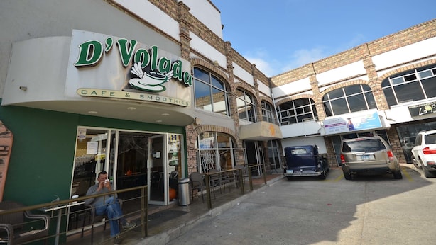 A cafe named D'Volga with a green awning and a signboard. - Hotel Suites del Sol (Tijuana)