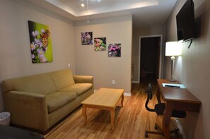 Suite, 1 grand lit et 1 canapé-lit, non-fumeur | Aire de séjour | Téléviseur connecté de 32 po avec télévision par câble, téléviseur