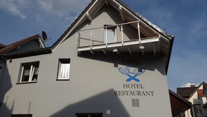 A building with a sign that reads "PEMPEL'S HOTEL RESTAURANT" and a logo featuring crossed chef's knives. - Hotel Restaurant Pempel (Grossalmerode)