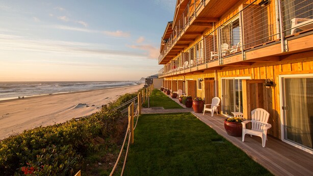 Un edificio de madera con balcones que dan a una playa.