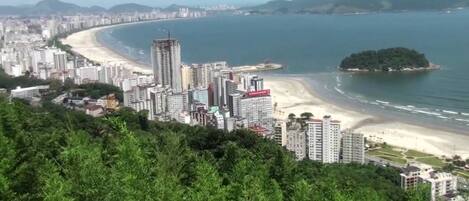 Un paisaje urbano costero con rascacielos, una playa y una pequeña isla.