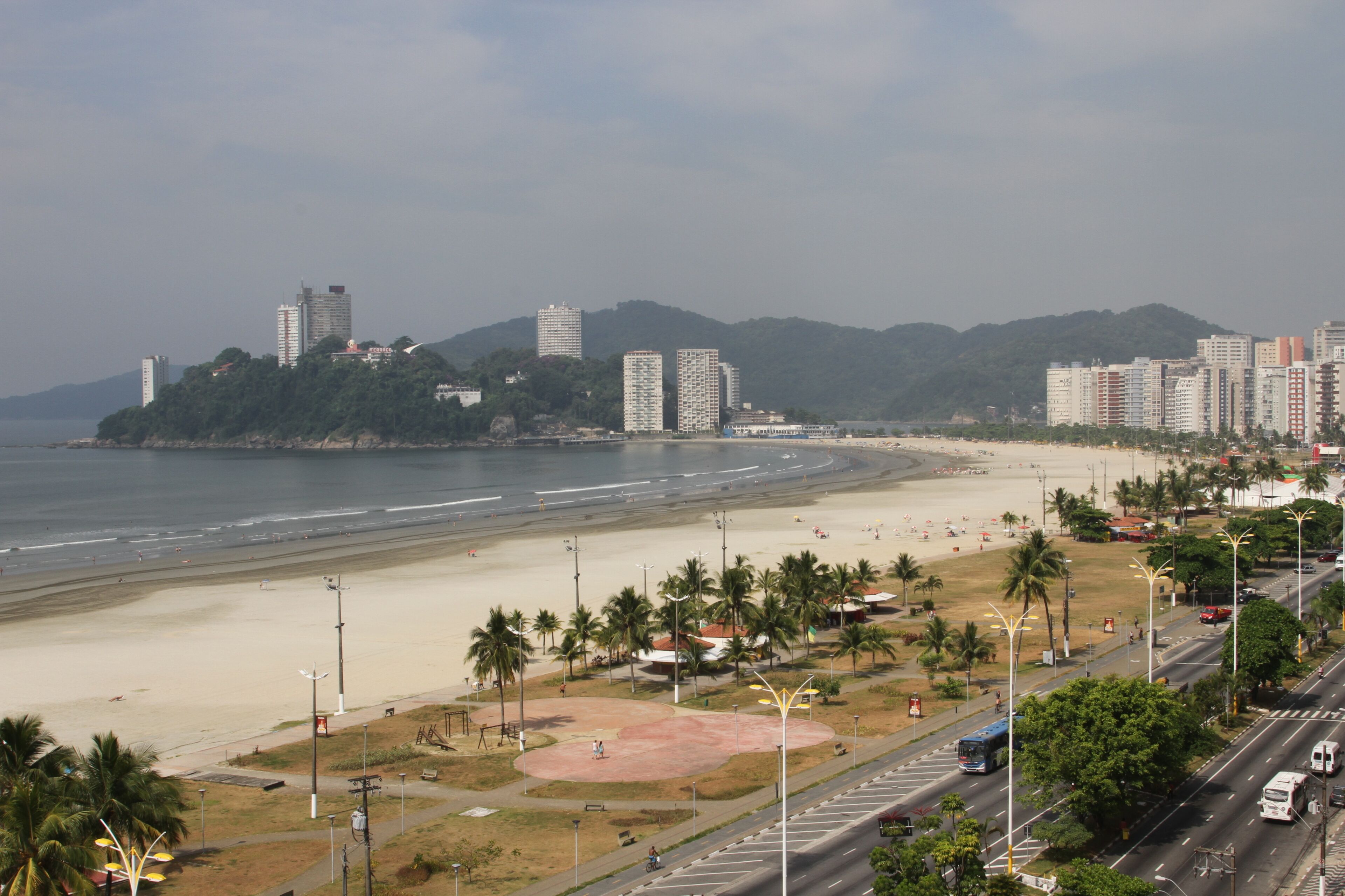 A coastal cityscape with a beach, high-rise buildings, and a clear sky.