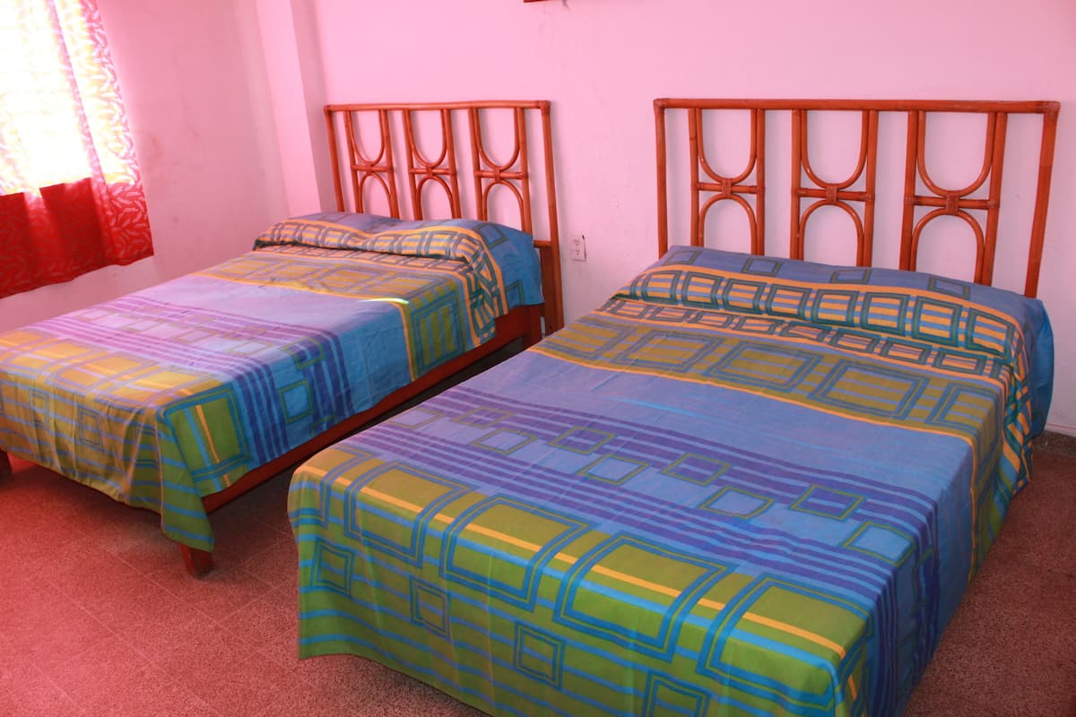 Habitación cuádruple económica, para fumadores | Cortinas blackout, camas extra y ropa de cama