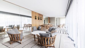 A modern interior with wooden furniture, a central round table, and a view of the city through large windows. - Top Rentals Dorrego (Buenos Aires)