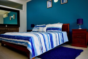 A bedroom with a bed, a dresser, a nightstand, and a mirror. - Ocean Front Luxury 2/2 in Whispering Seas (Tower isles)