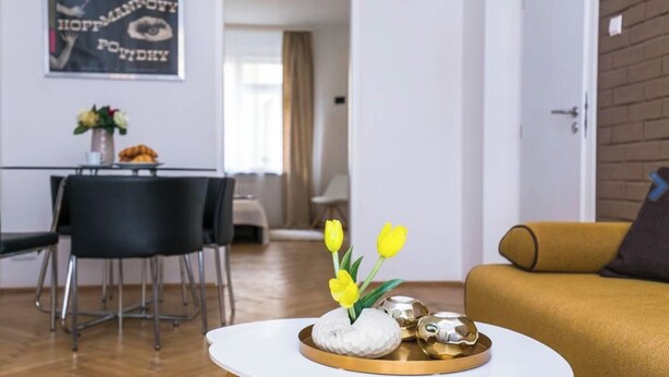 Un salon moderne avec une table basse ronde, un canapé et un coin repas comprenant des chaises et une table.