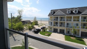 Ein mehrstöckiges Hotel mit Balkon, Parkplatz und Blick auf den Strand.