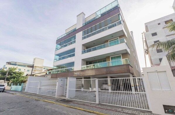 A multi-story building with a gated entrance, balconies, and a sign that reads "ARUBA".