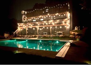 Un bâtiment à deux étages avec une piscine devant.