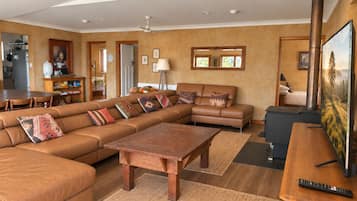 A spacious living room with a large sectional sofa, a wooden coffee table, and a television.