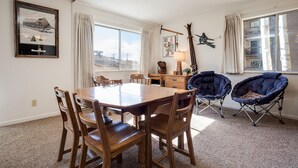 Un coin repas avec une table et des chaises en bois, une lampe et un tableau au mur.