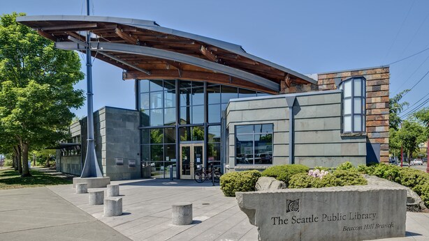 La Biblioteca Pública de Seattle, sucursal Beacon Hill, con un diseño arquitectónico moderno, amplias ventanas de vidrio y una entrada destacada.
