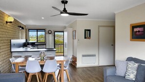 Una cocina moderna con comedor, ventilador de techo y vistas por una puerta corredera.