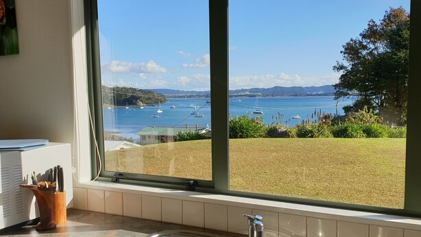 Cozinha com uma grande janela com vista para um porto com barcos.