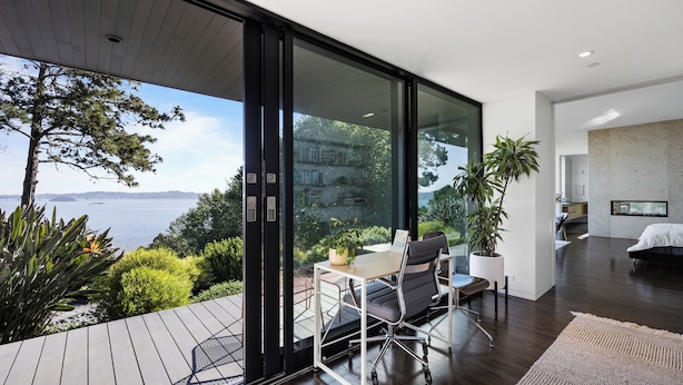 A modern room with a glass door leading to a balcony overlooking a body of water. - Award-winning ocean view luxury master suite. Perfect romantic retreat (Tiburon)