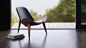 A modern chair by a large window overlooking a body of water and greenery. - Award-winning ocean view luxury master suite. Perfect romantic retreat (Tiburon)