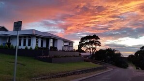 A modern house with a 'No Through Road' sign, surrounded by well-maintained lawns and a large tree. - C'EST LA VIE: Panoramic views. Bed & Breakfast (Mira Mar)