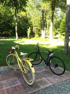Cyclists can ride along the paved walkway surrounded by lush greenery.
