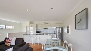 A modern kitchen with white cabinets, stainless steel appliances, and a central island. - Seascape  1 - Water views (BERMAGUI)