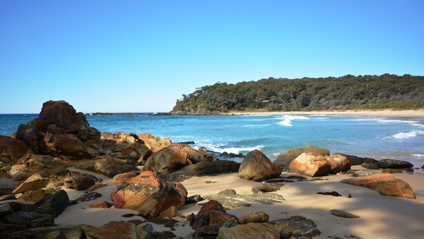 A rocky beach with large boulders and a clear view of the ocean. - 11 Burrawong Place - Bushland Haven (BARRAGGA BAY)