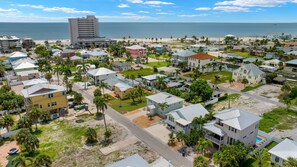 A coastal residential area with houses, a beach, and a large hotel.