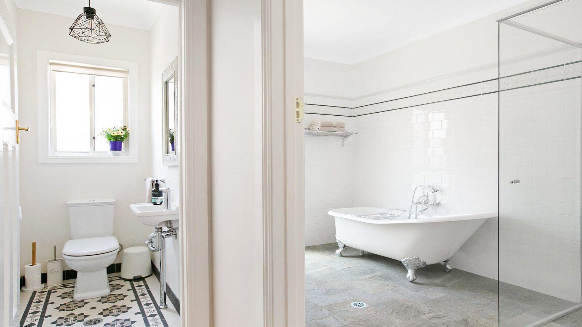 Un baño moderno con una bañera independiente, inodoro y lavamanos.