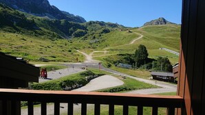 A mountain landscape with a road leading to a building with a red roof. - Pierre De Soleil -  Ski in/out, next to ski school, shops/restaurants -free wifi (Mâcot-la-Plagne)