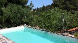 A swimming pool with a stone border, surrounded by trees and a clear sky. - Great House with Garden between Sea and Mountain (Riudecanyes)
