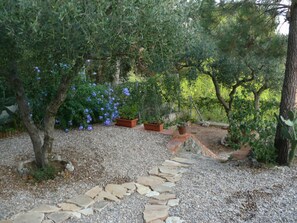 A garden with a gravel path, potted plants, and trees. - Great House with Garden between Sea and Mountain (Riudecanyes)