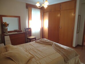 Ein Schlafzimmer mit einem Bett, einem Schreibtisch, einem Stuhl und einem Kleiderschrank.