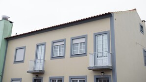 Un edificio a più piani con balconi, un tetto piano e un numero civico ben visibile.