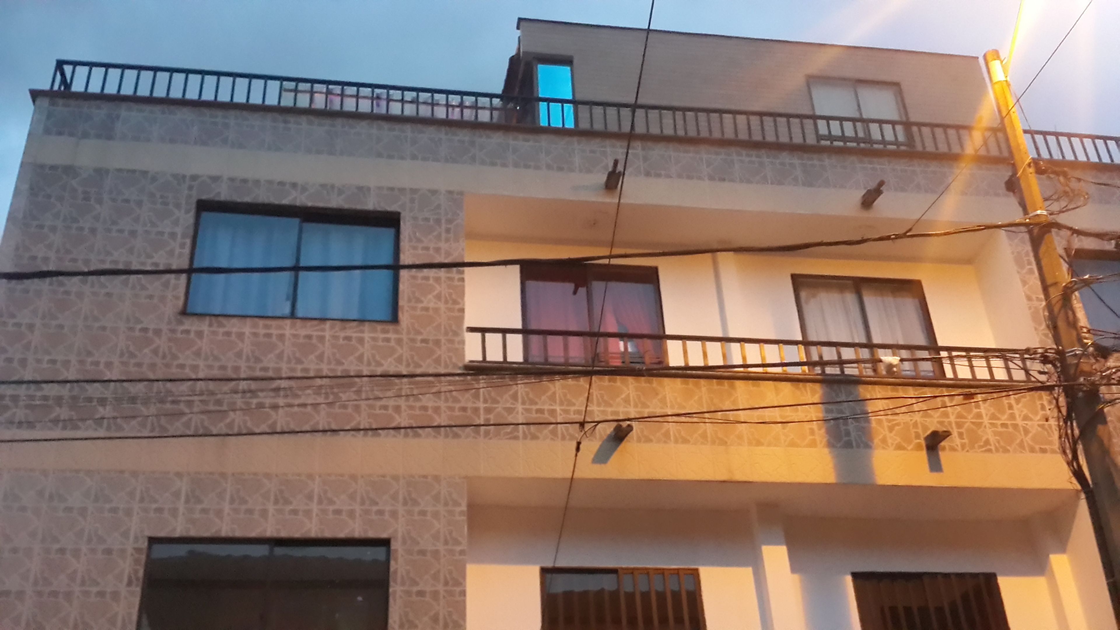 A multi-story building with a balcony on the upper floor.