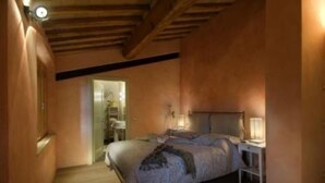 A bedroom with a bed, bedside table, and a nightstand.