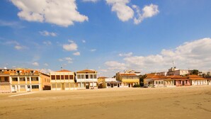 A coastal area with buildings along the shore, featuring a sandy beach and a clear sky. - Private House with Exclusive Swimming Pool Heated and Amazing View (Boccheggiano)