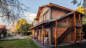 A two-story building with a brick facade, wooden beams, and a covered porch. - Los Maitenes Bariloche (San Carlos de Bariloche)