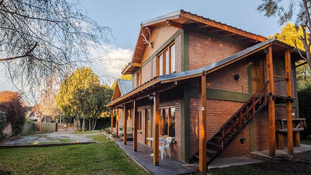 A two-story building with a brick facade, wooden beams, and a covered porch. - Los Maitenes Bariloche (San Carlos de Bariloche)