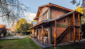 A two-story building with a brick facade, wooden beams, and a covered porch. - Los Maitenes Bariloche (San Carlos de Bariloche)