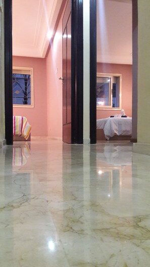 Une chambre d’hôtel avec un lit, une fenêtre et une salle de bain visible à travers une porte ouverte.
