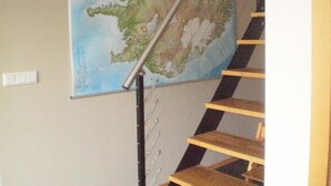 A staircase with a metal handrail and wooden steps. - Guesthouse Dalbaer (Hrunamannahreppur)