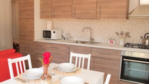 A modern kitchen with wooden cabinets, a microwave, a sink, and a stove.