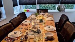 A dining table set for six with white plates, silverware, and glassware, decorated with small lights and greenery. - Vacation apartment for 11 persons (incl. consumption costs and tourist tax!) (Zeewolde)