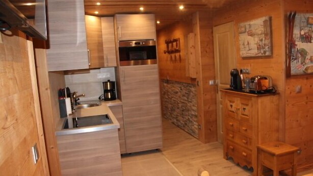 A compact kitchen with wooden cabinets, a built-in oven, and a coffee maker. - Studio - VAL THORENS (Les Belleville)