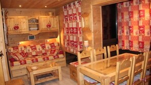 A cozy wooden cabin interior with a sofa, dining table, and chairs. - Studio - VAL THORENS (Les Belleville)