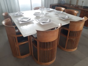 Une table à manger dressée avec des assiettes, des bols et des couverts.
