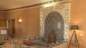 Una sala acogedora con una disposición de asientos, un muro decorativo y una lámpara de pie.
