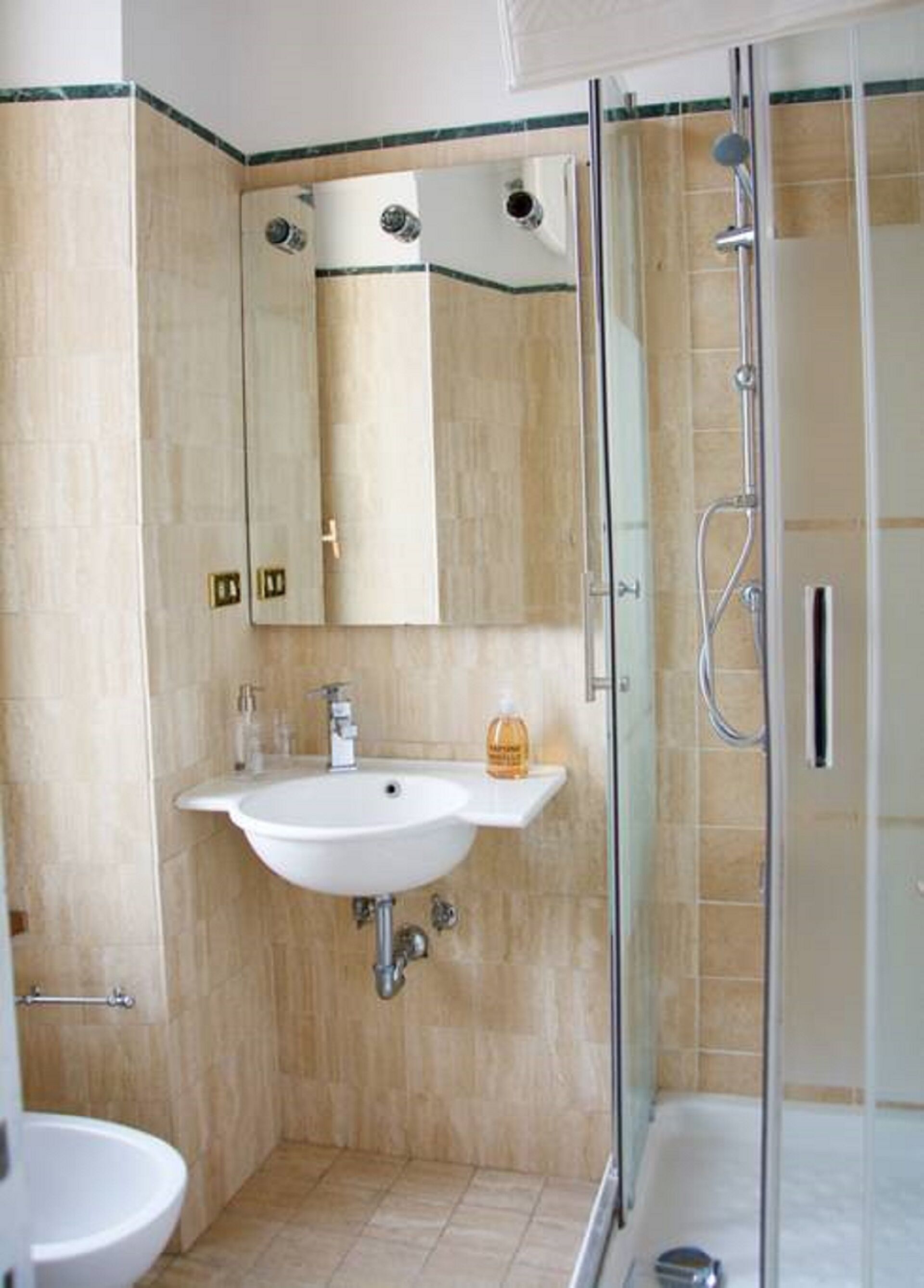 Ein Badezimmer mit Waschbecken, Spiegel und Dusche.