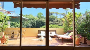 An outdoor patio with a covered seating area, a table, and chairs. - Flaminio Penthouse with Spectacular Terrace (Roma)