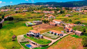 Vue aérienne d’un quartier résidentiel avec des maisons, des pelouses verdoyantes et une piscine.