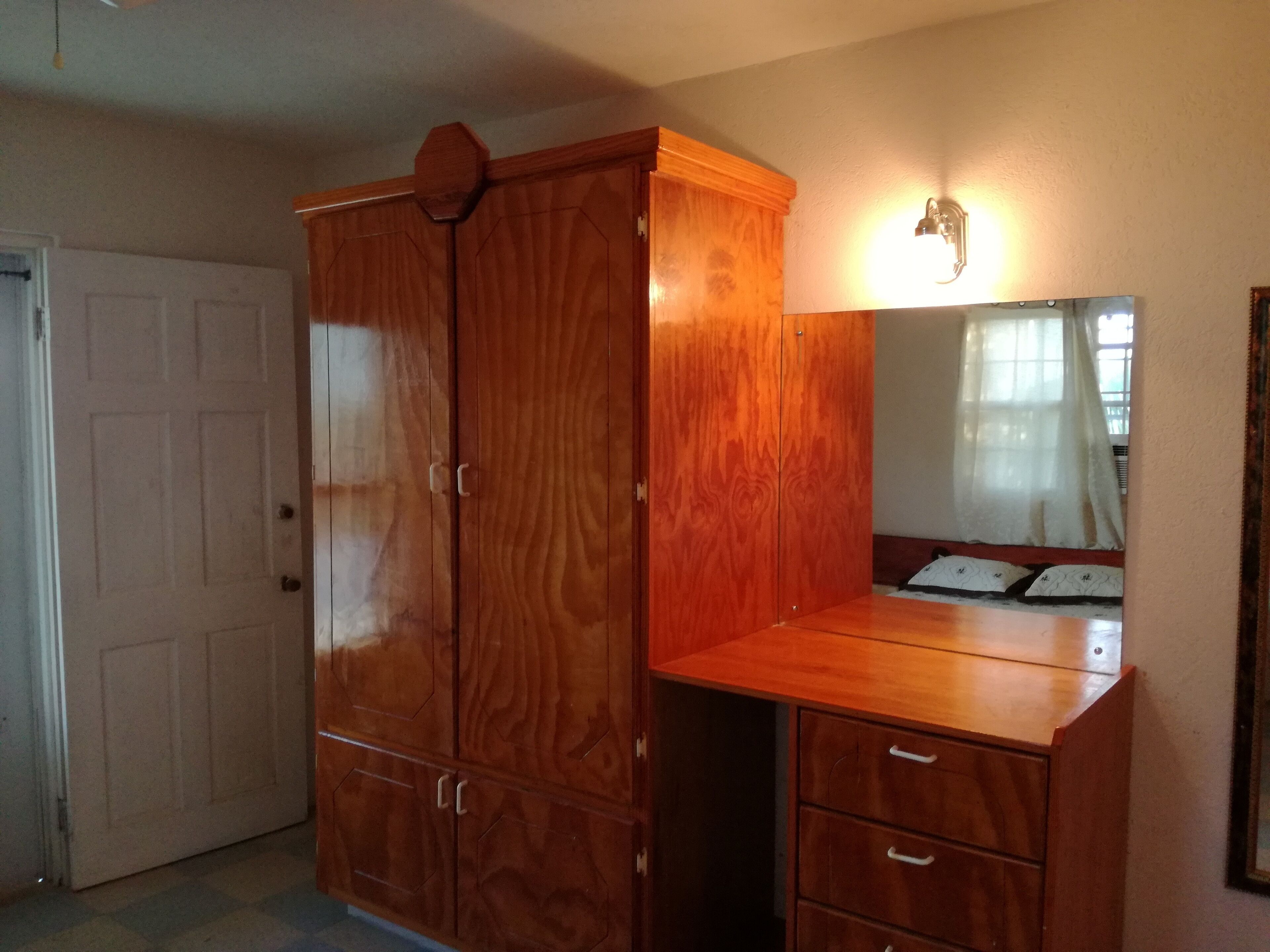 Une armoire en bois dotée de plusieurs compartiments et d’un miroir.