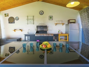 Een moderne keuken met een centraal eiland, een inbouwoven en een koelkast.